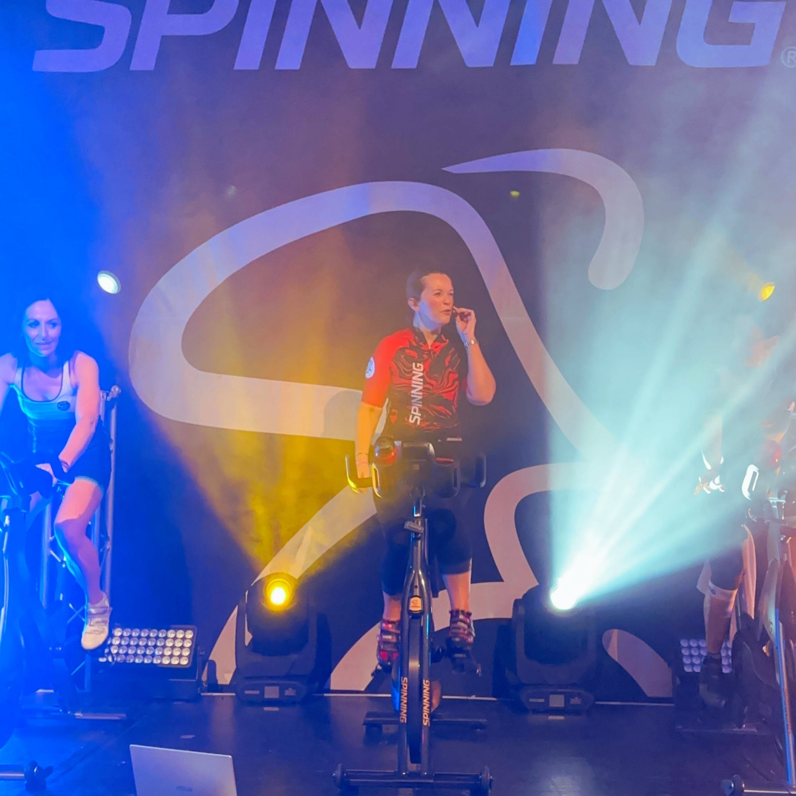 Instructor leading a Spinning® class with motivated riders in a studio setting — become a certified Spinning® Instructor with Athleticum®, the official UK & Ireland education partner.