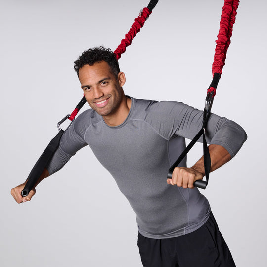 Man exercising with 4D PRO® Bungee Trainer System plain background