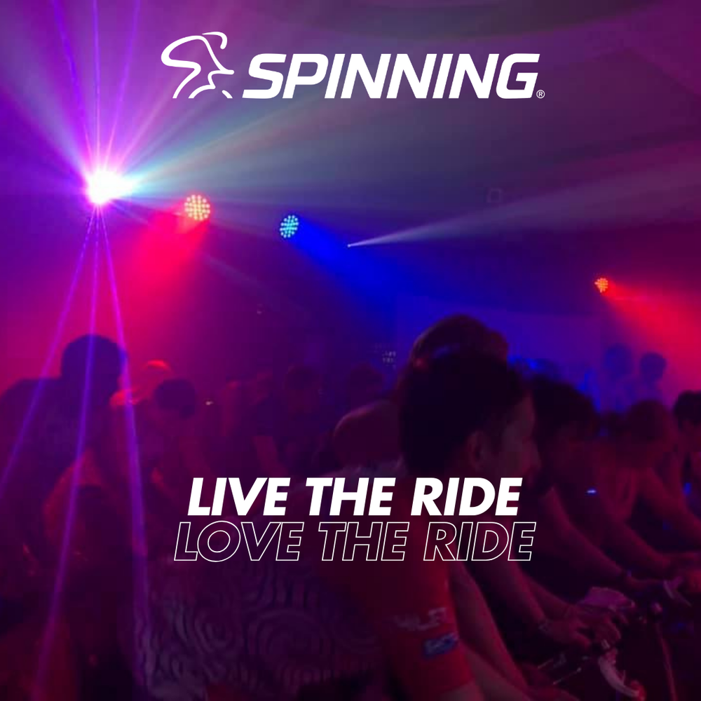 Amazing atmospheric Spin® indoor cycling room full of people 