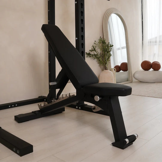 Black adjustable weight bench in a home gym setting with decor elements.