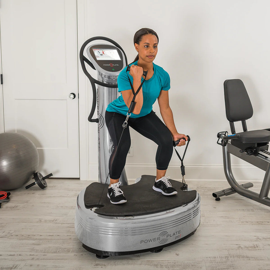 Woman using Silver Power Plate pro7 in a home gym setting